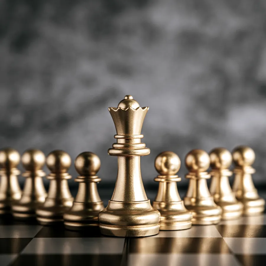Une dame d'échecs dorée se détache en avant de ses pions alignés : la décision qui ouvre la voie.